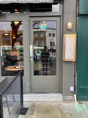 Glass door with grey frame and metal handle on left.