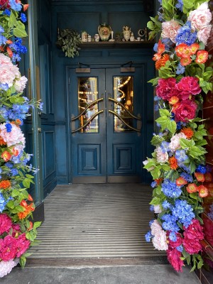 Glass door with wood frame ahead. Pull from metal handles in centre to open