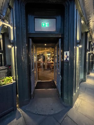 Wooden double doors with glass panels. Pull from middle to open. Small bump before doors.