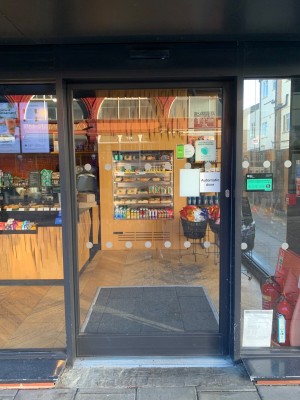 Glass door with black frame ahead. Automatic door slides to left when opening.