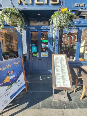 Open step up to blue framed glass door. Push metal handle on left to open. Obstructions on both sides of entrance door.
