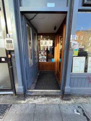 Glass door with grey wooden frame. Push from right to open.