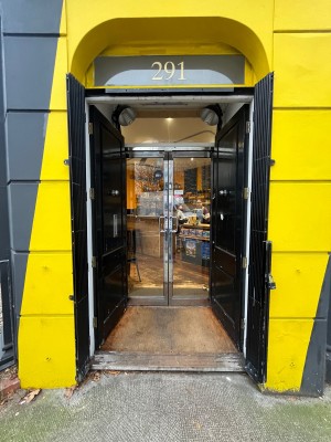 Black wooden doors. Push from middle. Glass doors with silver metal frame behind. Push from middle.