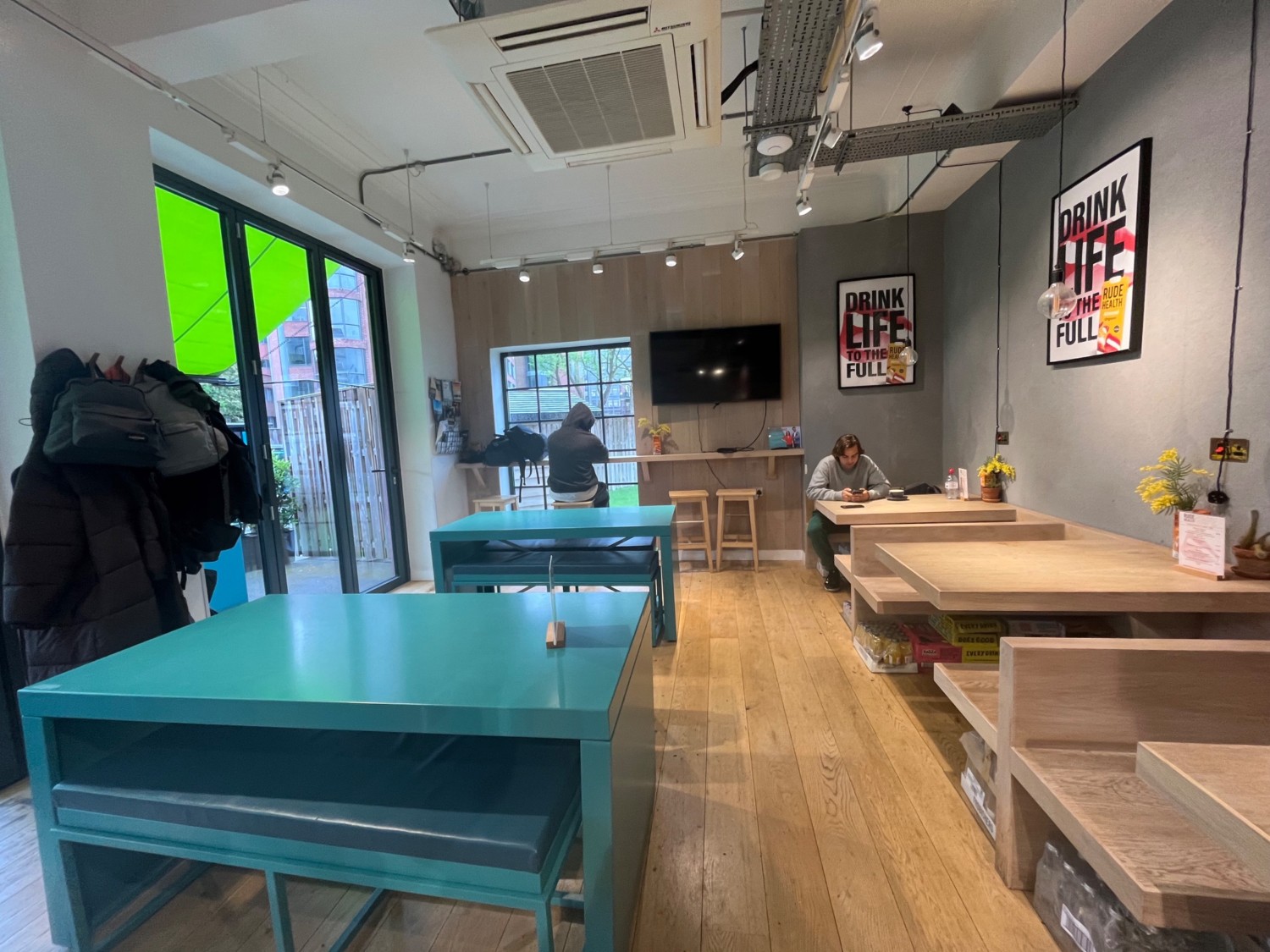 From right of shelves facing straight. Path straight. Tables and benches left. Booths right. High table and stools at end of path.