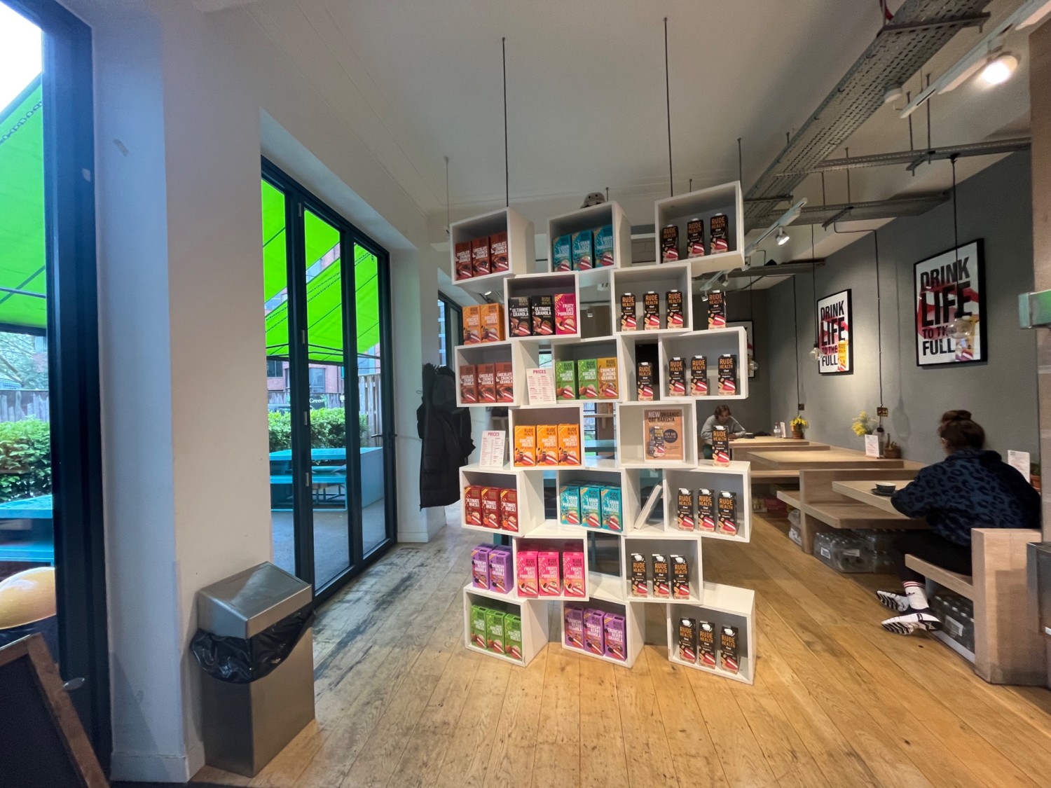 From counter facing left. Shelving ahead. Paths to seating on left and right of shelves.
