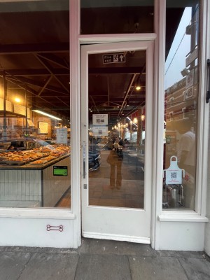 Glass door with white wooden frames ahead. Push from left to open.