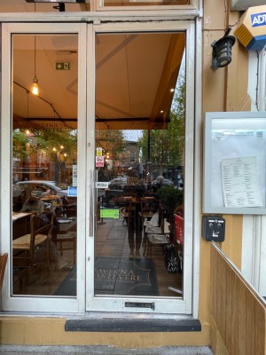 Glass door with white frame. Push silver handle on left to open.