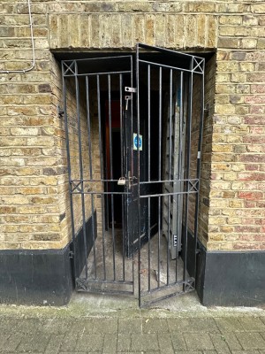 From pavement on right-side of venue looking straight at first set of gated double doors. Pull from centre to open.