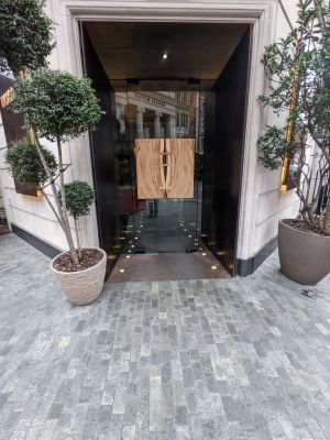 Glass door with wooden panel in middle. Push from right to open.