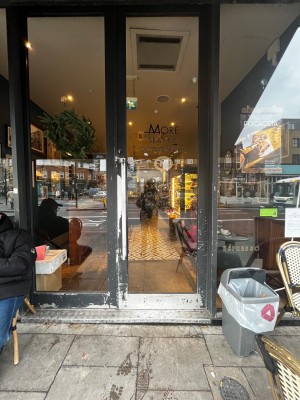 Glass door with dark grey frame. Push handle on left to open.