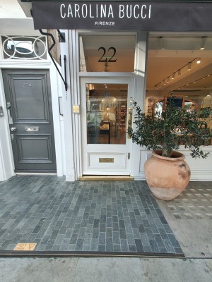 One step up to entrance. White framed glass door. Push from right to open.