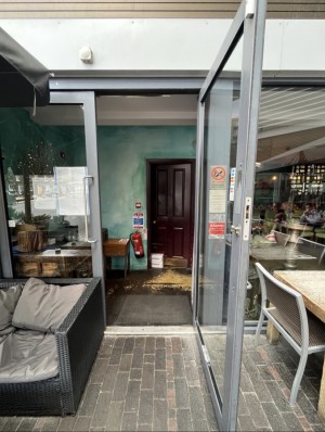 Metal-framed glass door. Pull from silver handle on left to open.