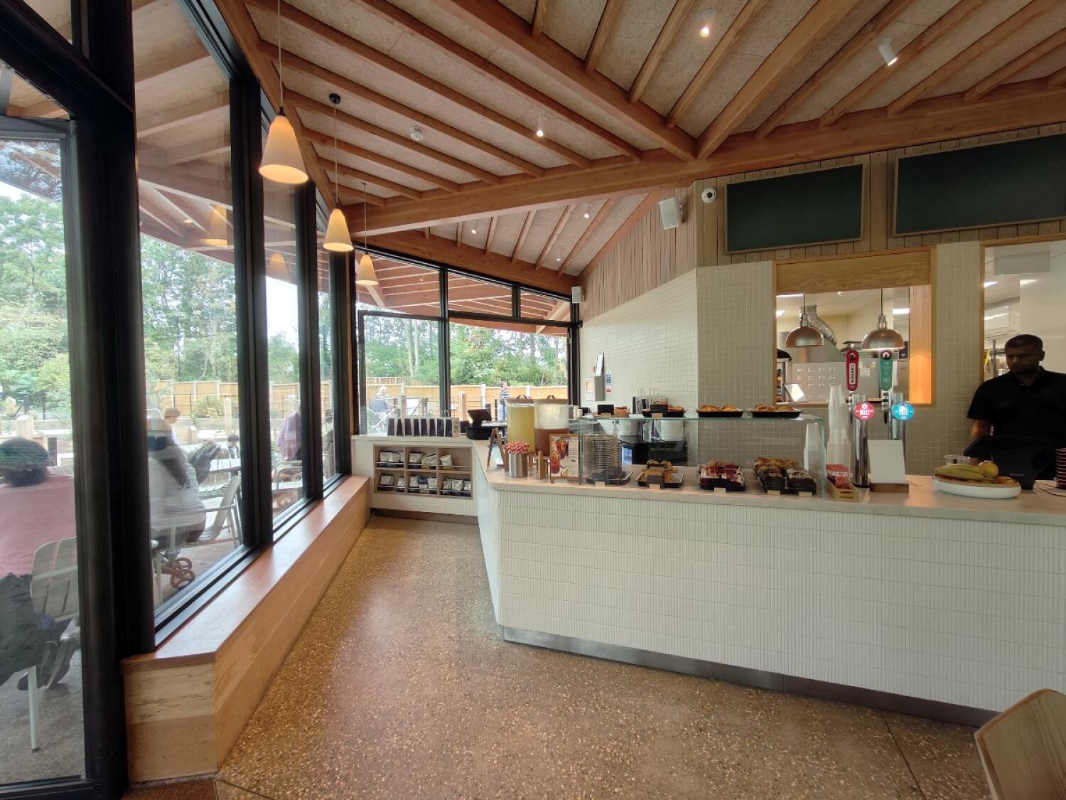 Windows and ledge along left. Open floor in centre. Display counter along right.