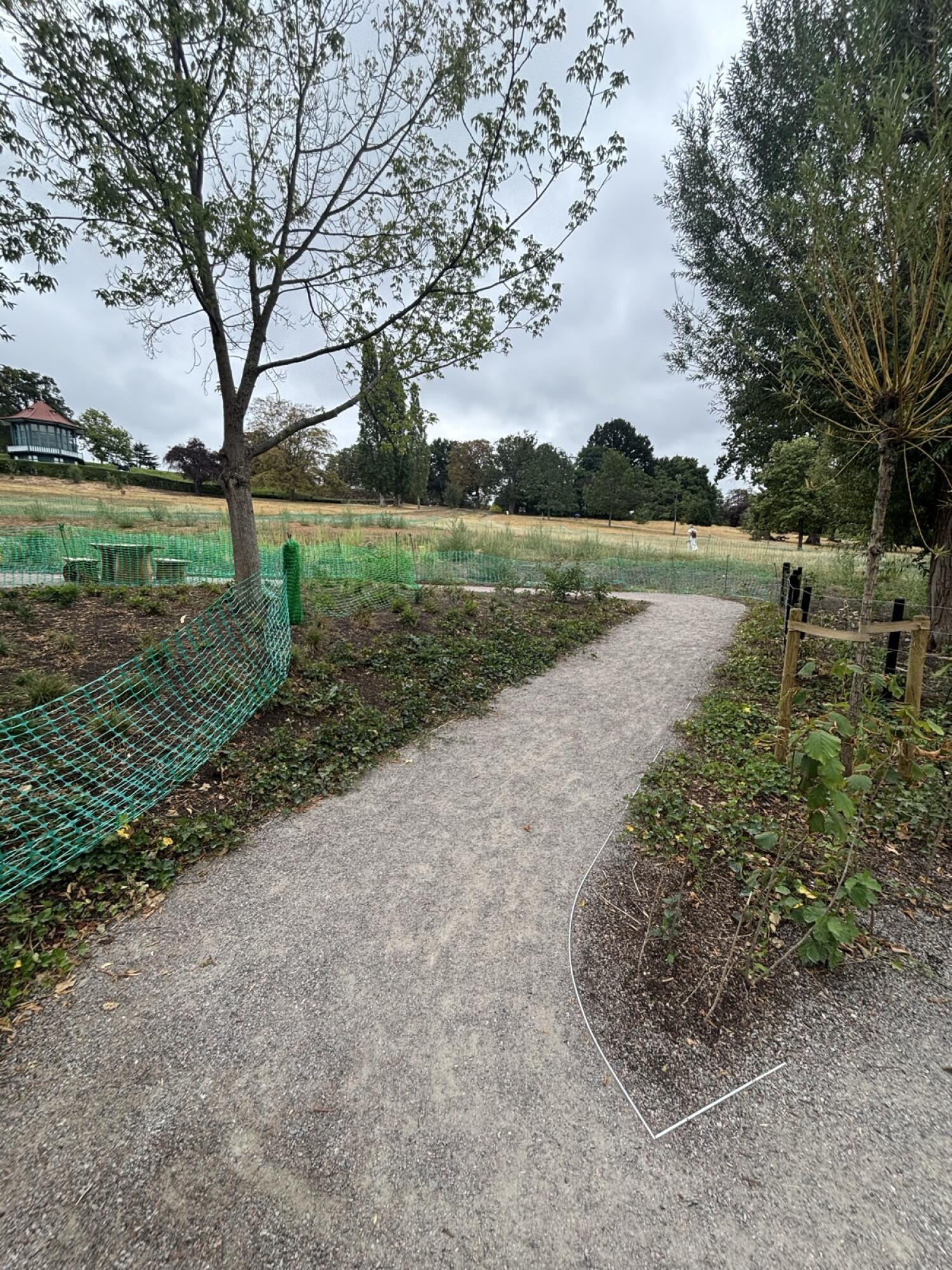 Gravel path curves right through planted park area.