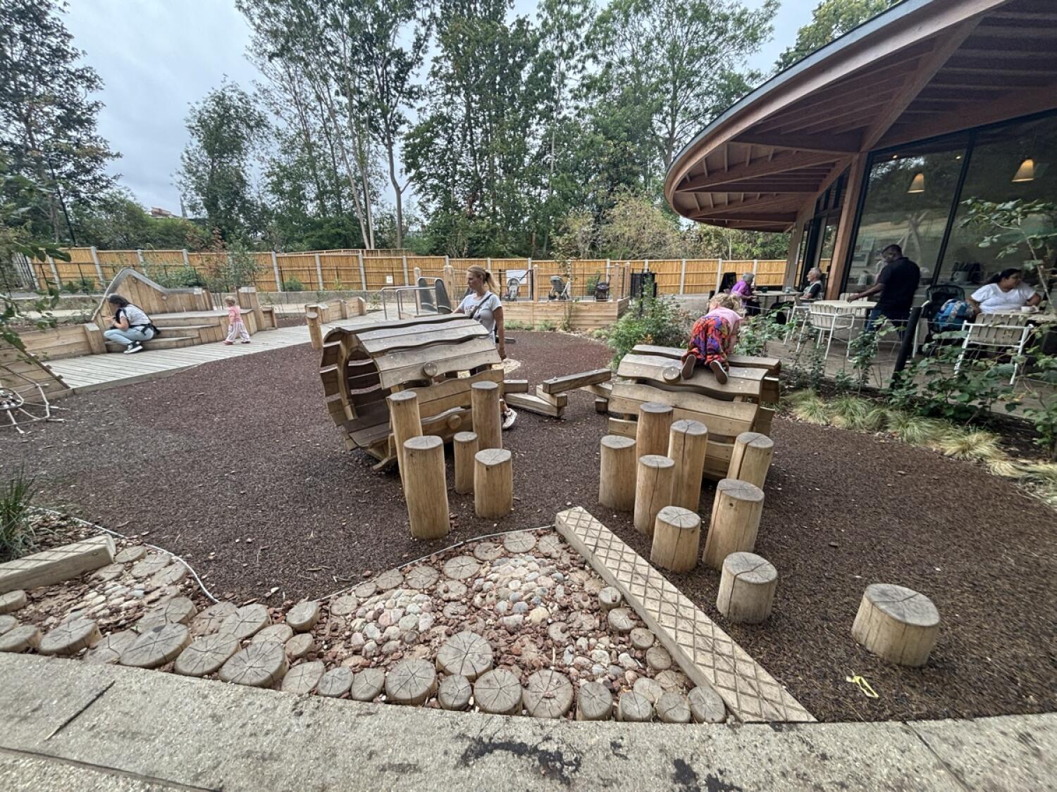 From after gate facing right. Outdoor play area ahead with log stepping posts.