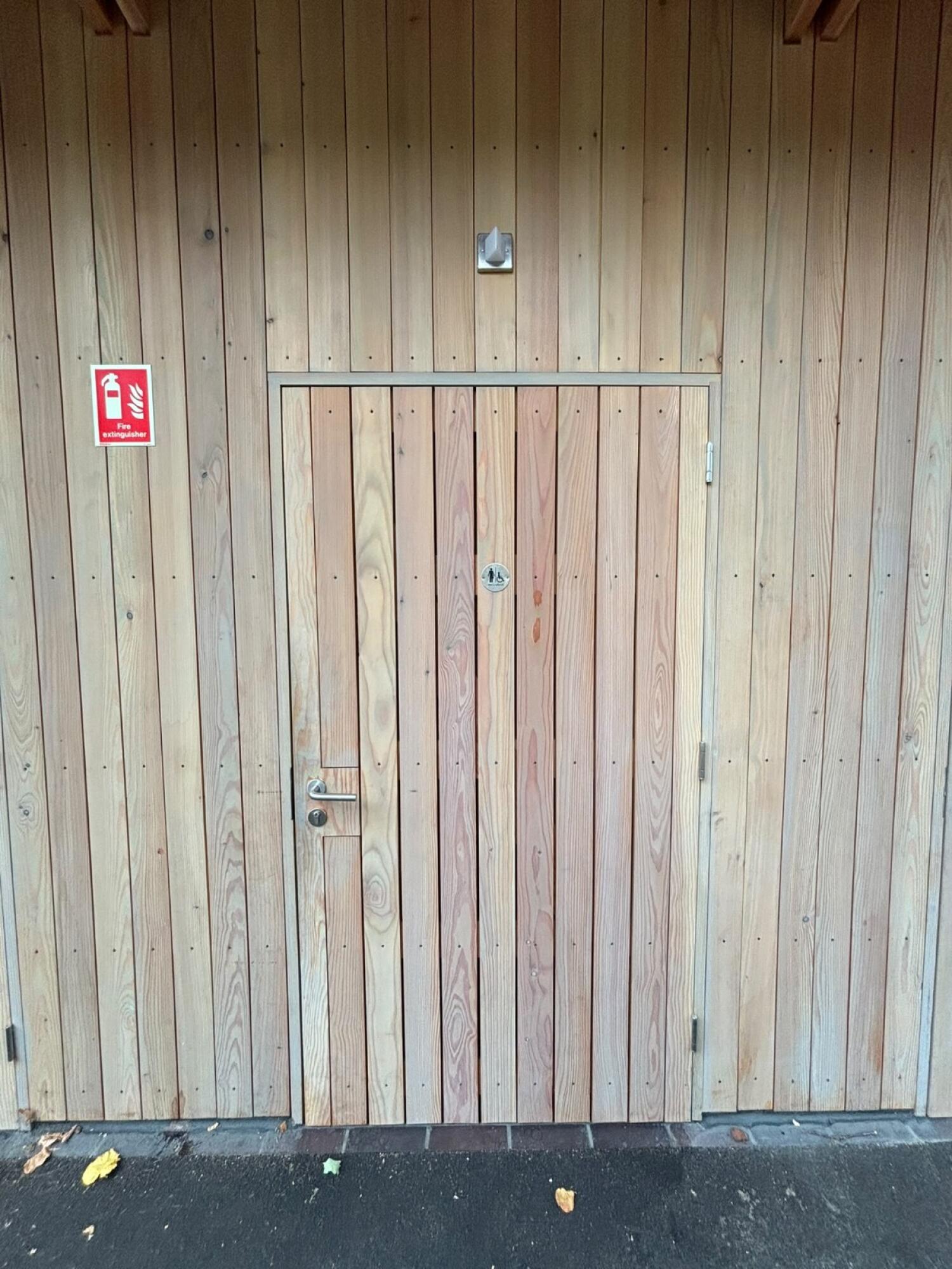 Wood-panelled door. Use handle to open.