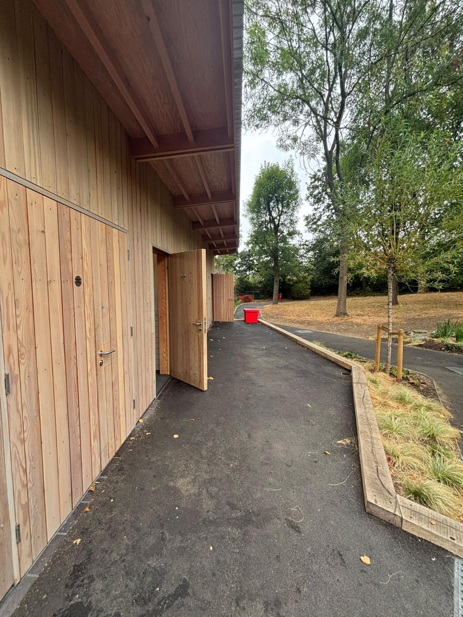 Open door on left along paved path.