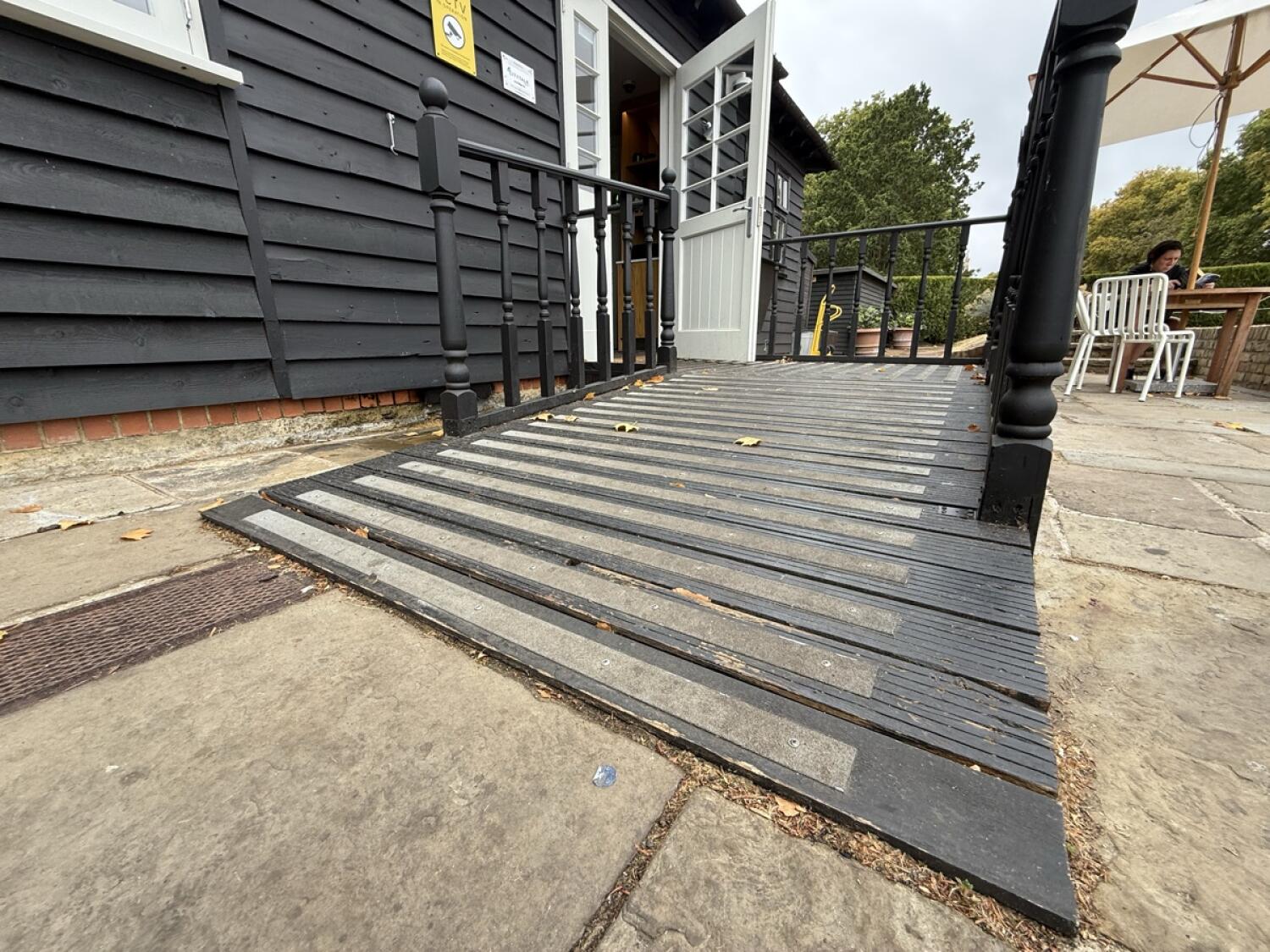 Ramp with handrails leads to open doorway ahead.