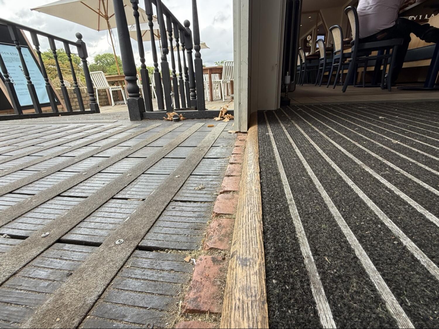 Small bump at foot of door. Doormat before door.