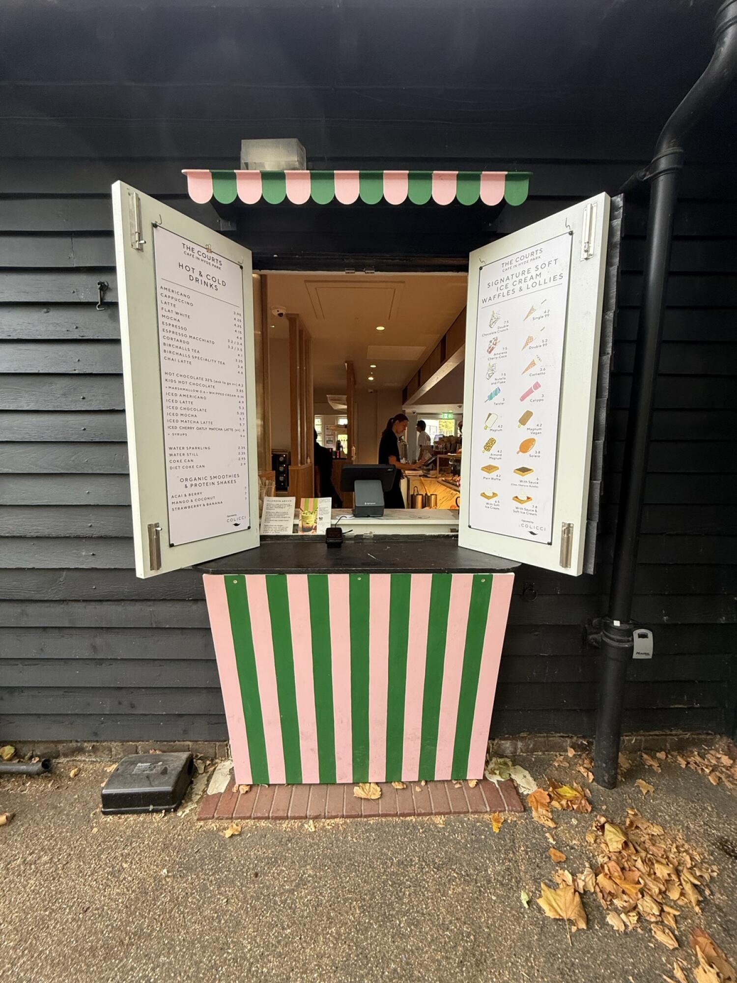From after planter facing straight. Service window in centre. Menu boards on open shutters. Counter below window.