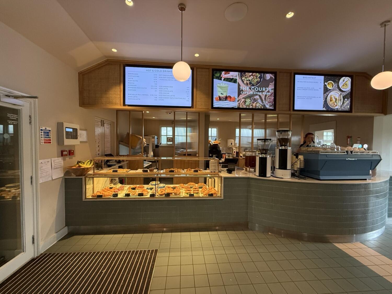 From entrance facing left. Display counter in centre. Service counter on right. Menu screens above.