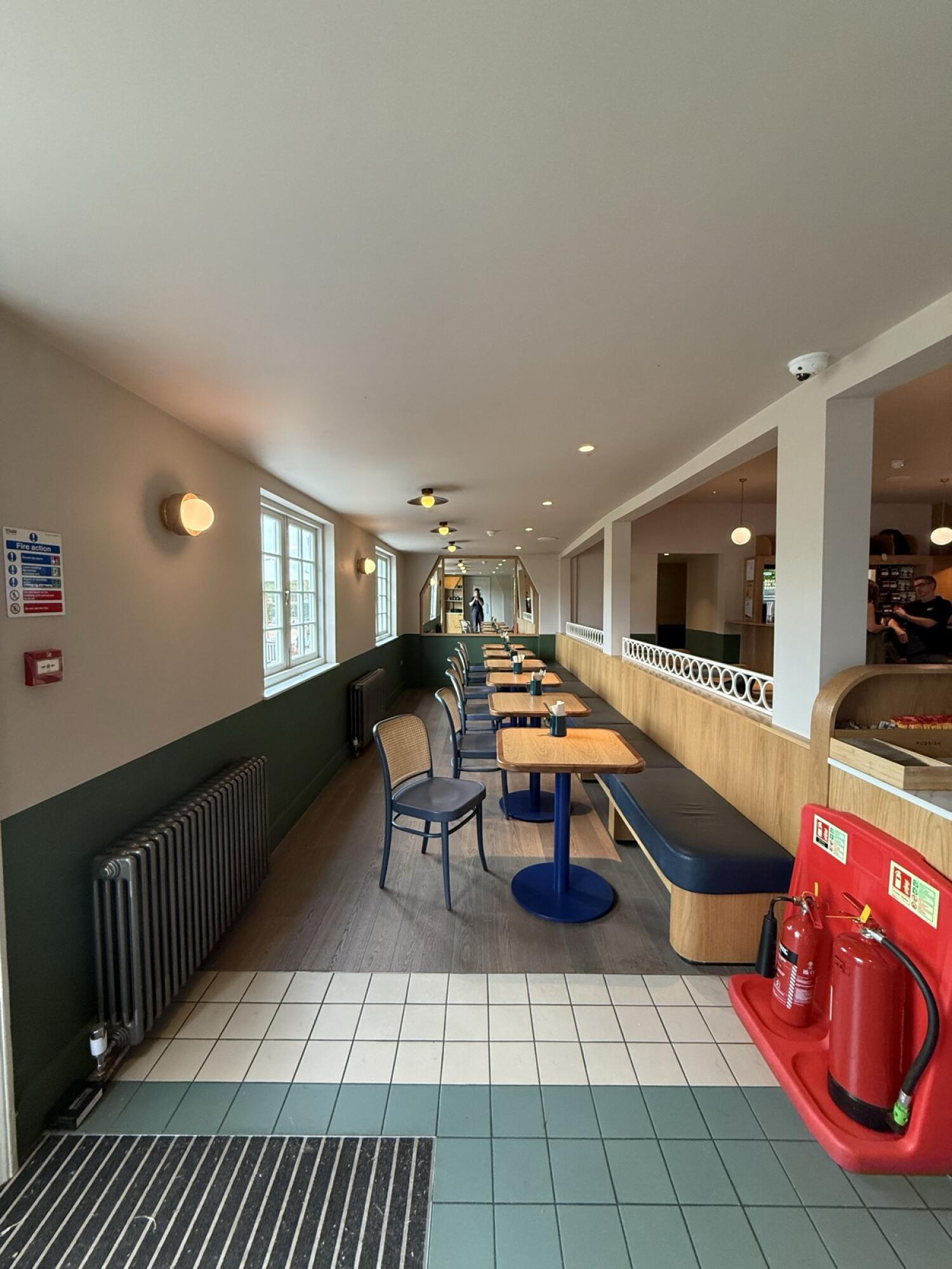 From after condiment counter facing right. Half booth and chairs along right.