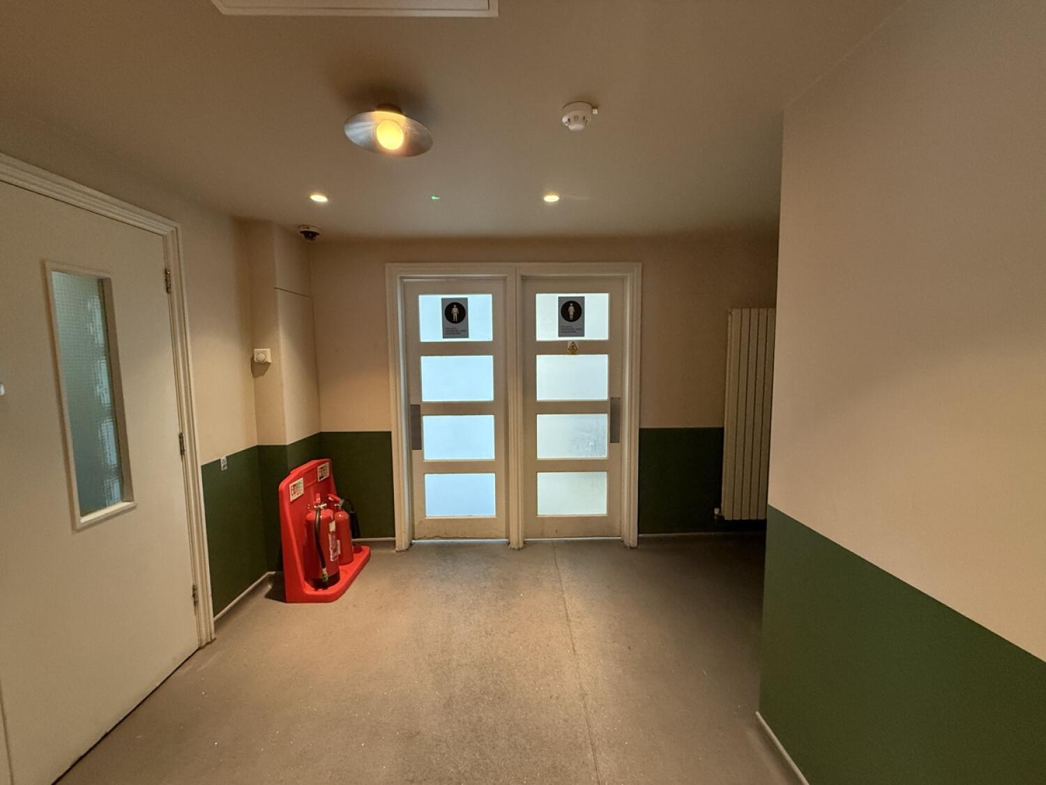 From after archway facing straight. Men's bathroom back left, women's bathroom back right.