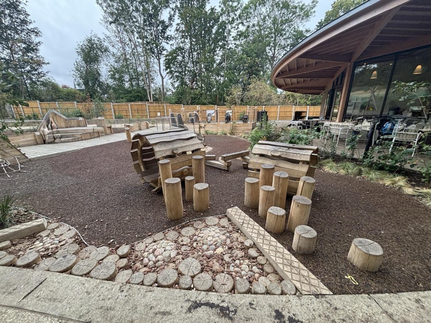 From after gate facing right. Outdoor play area ahead with log stepping posts.