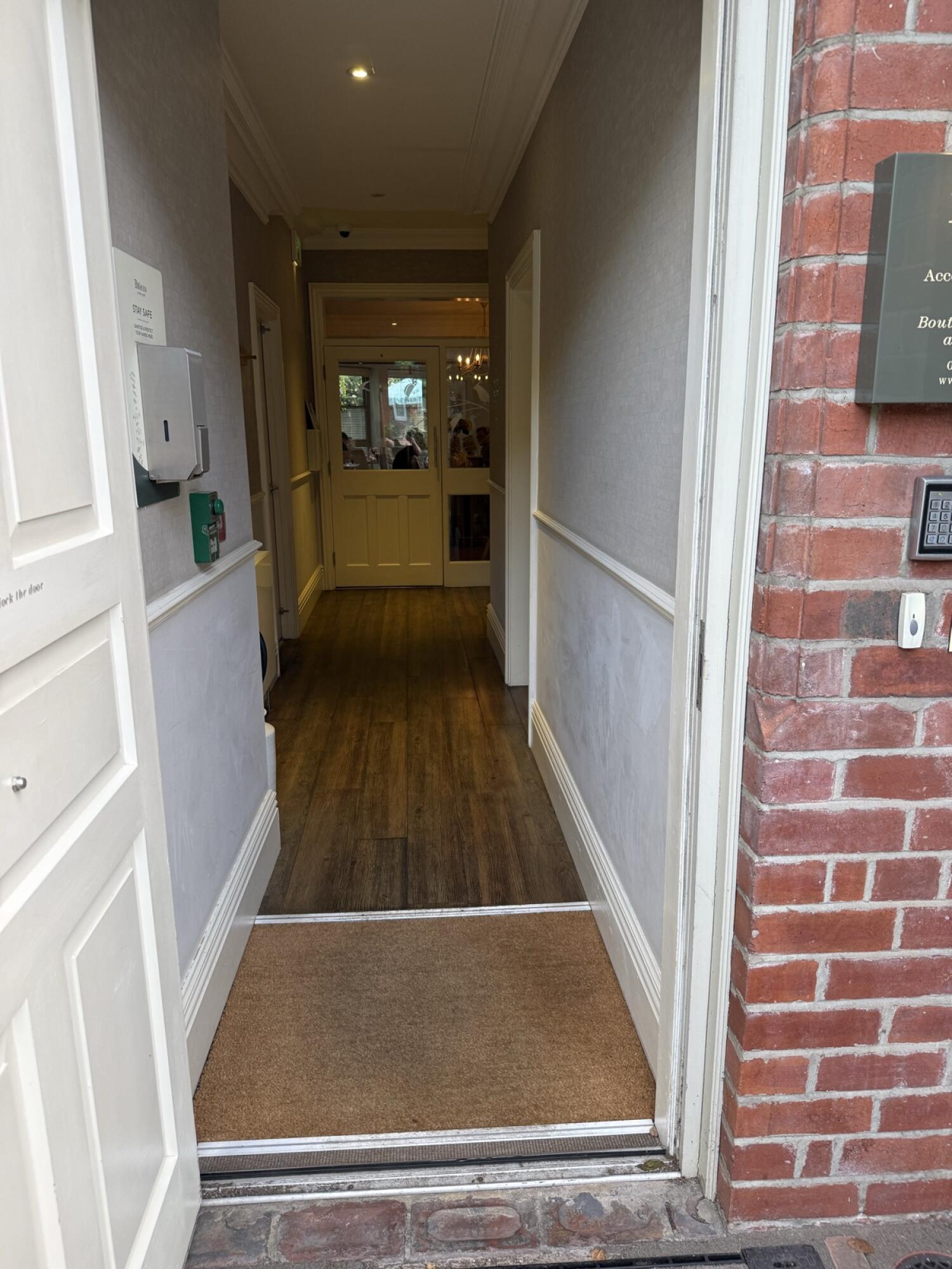 White wooden door, open inward. Hallway visible beyond doorway.