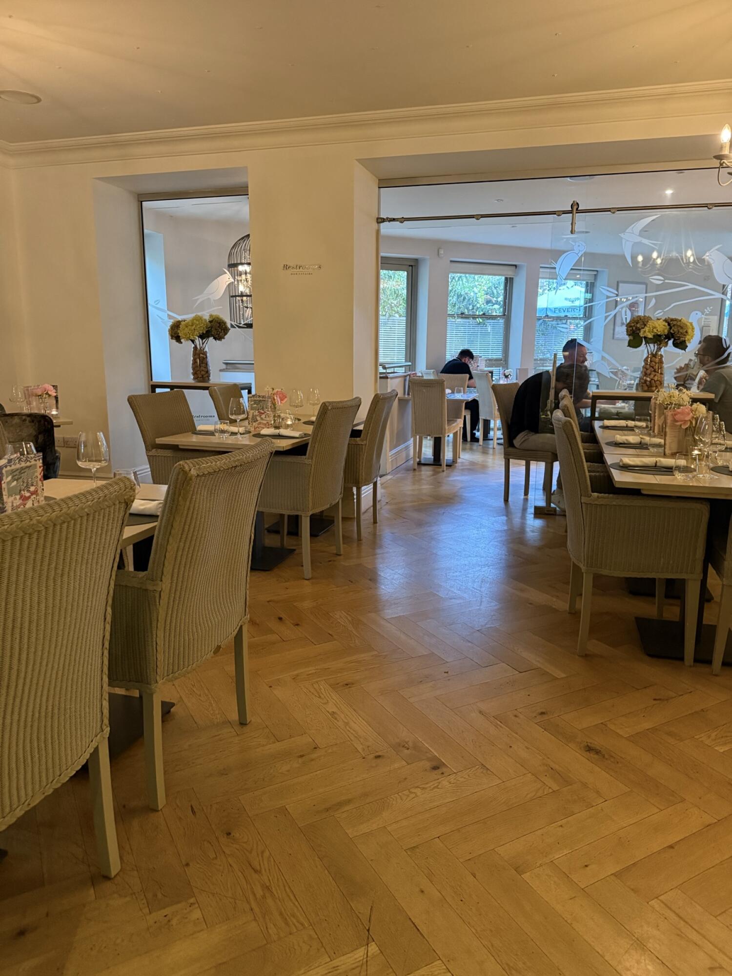 Tables and chairs along left. Open path through centre. Tables and chairs along right.