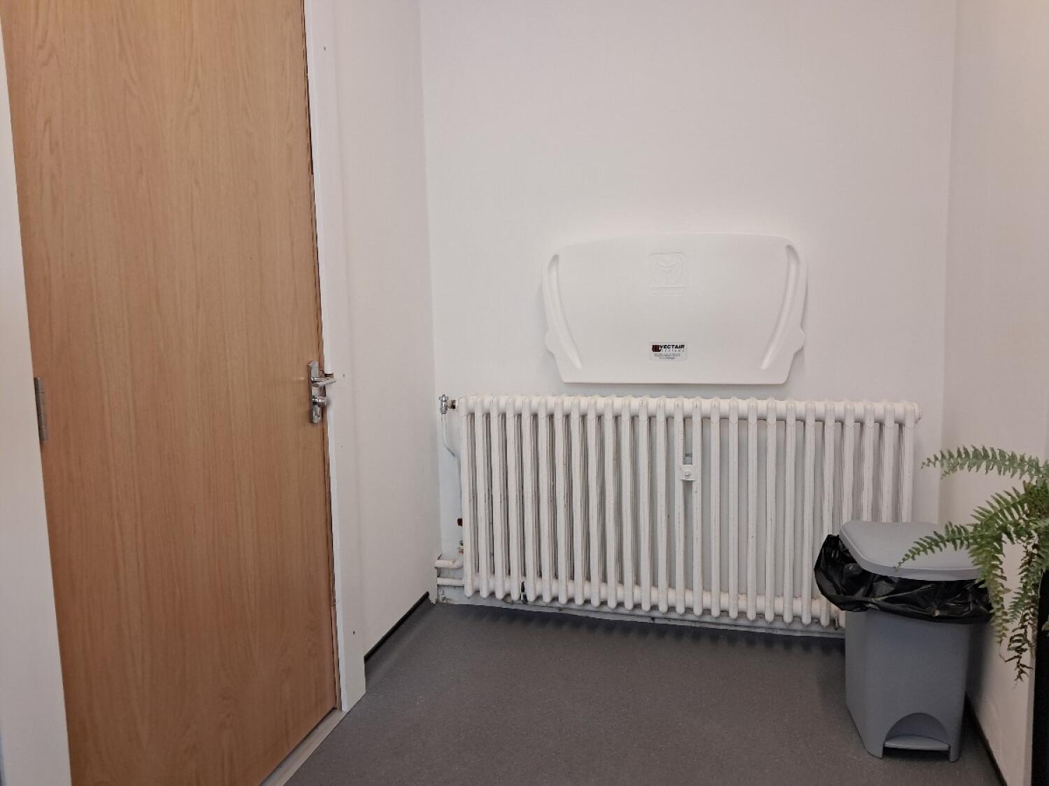 Baby changing station on back wall. Door on left.