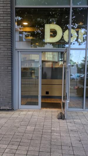 Grey metal-framed glass door. Use handle to open.