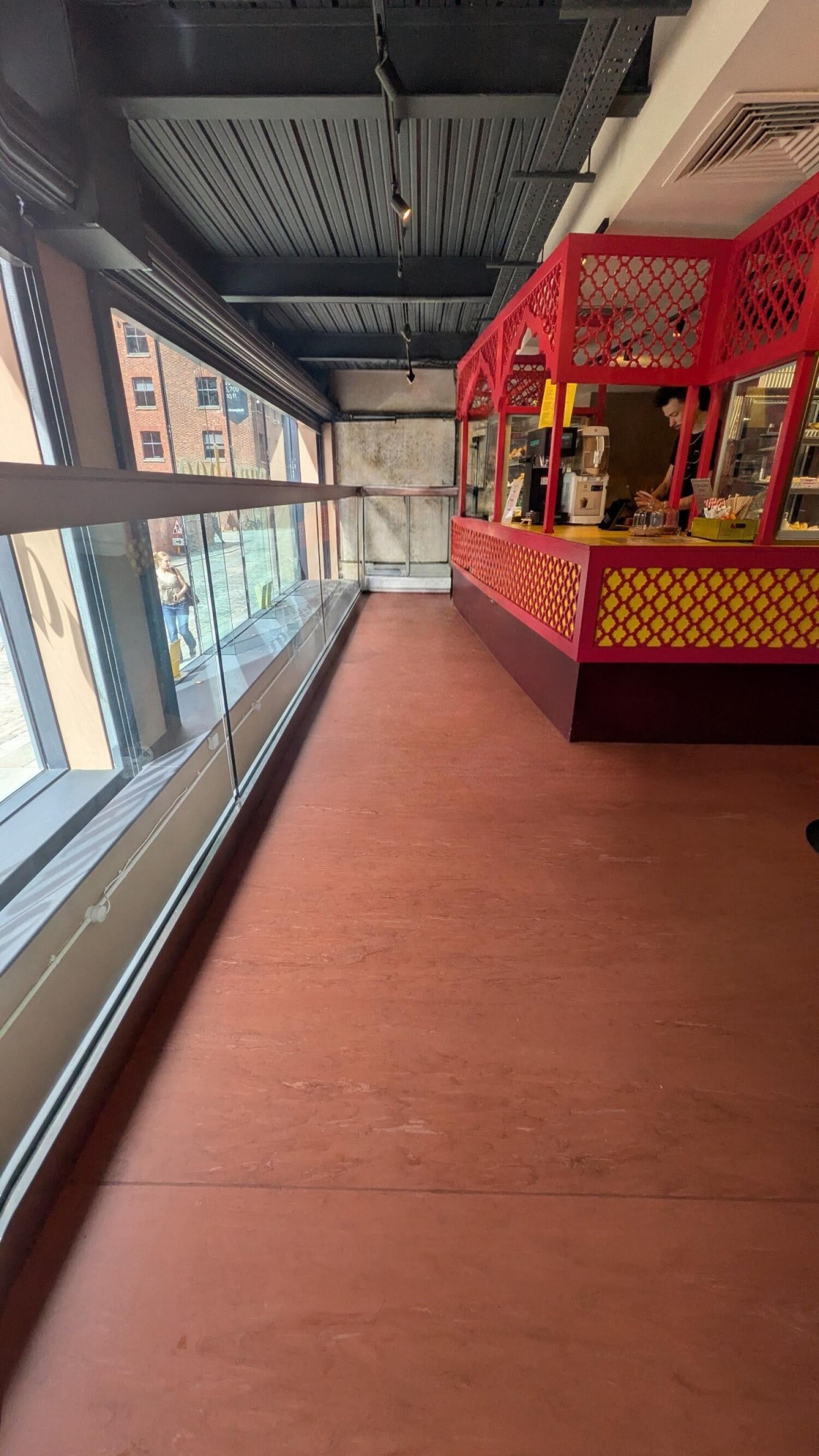 Windows along left. Clear path through centre. Service counter along right.