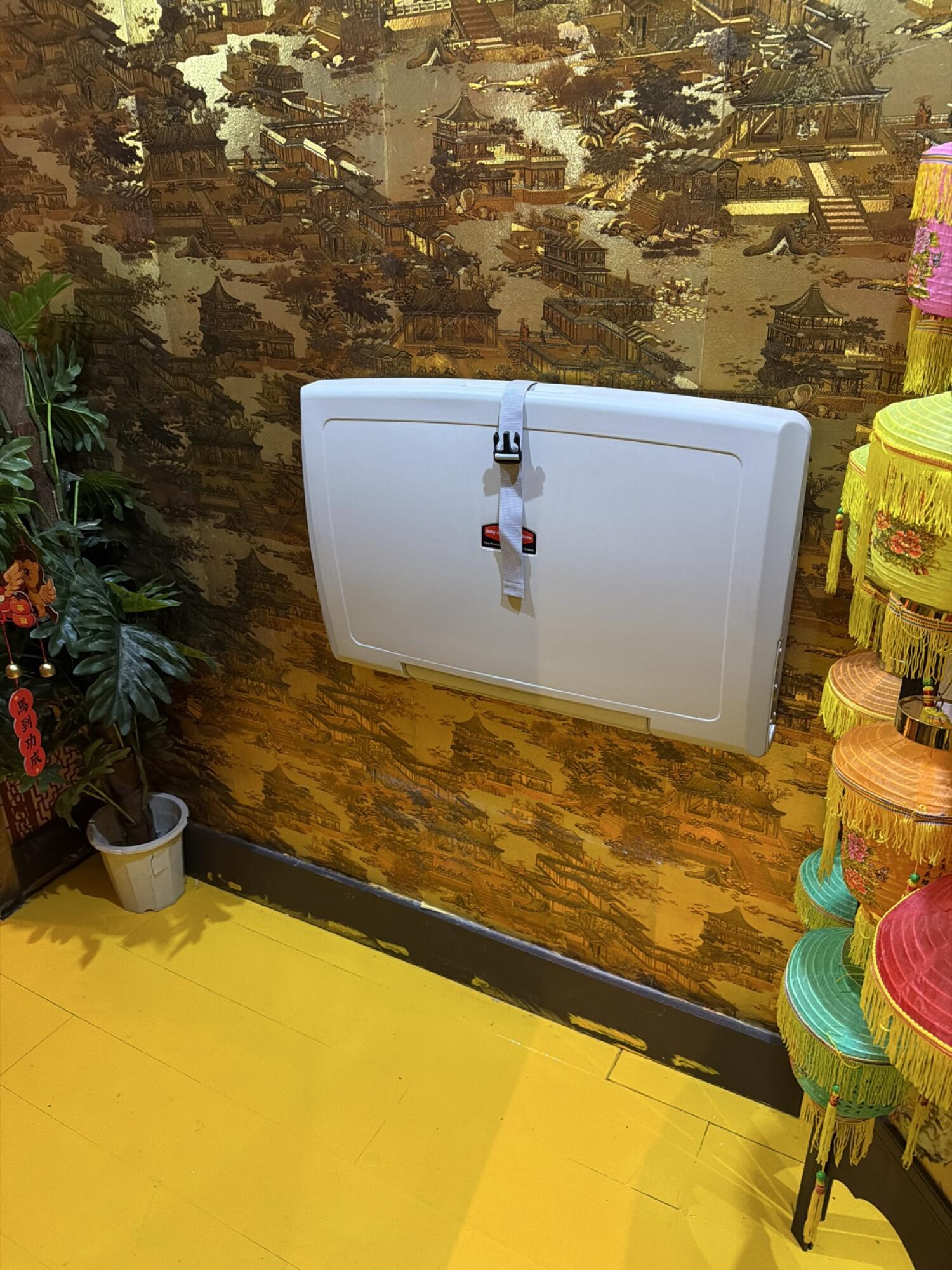 Baby changing station in centre. Clear floor space in front.
