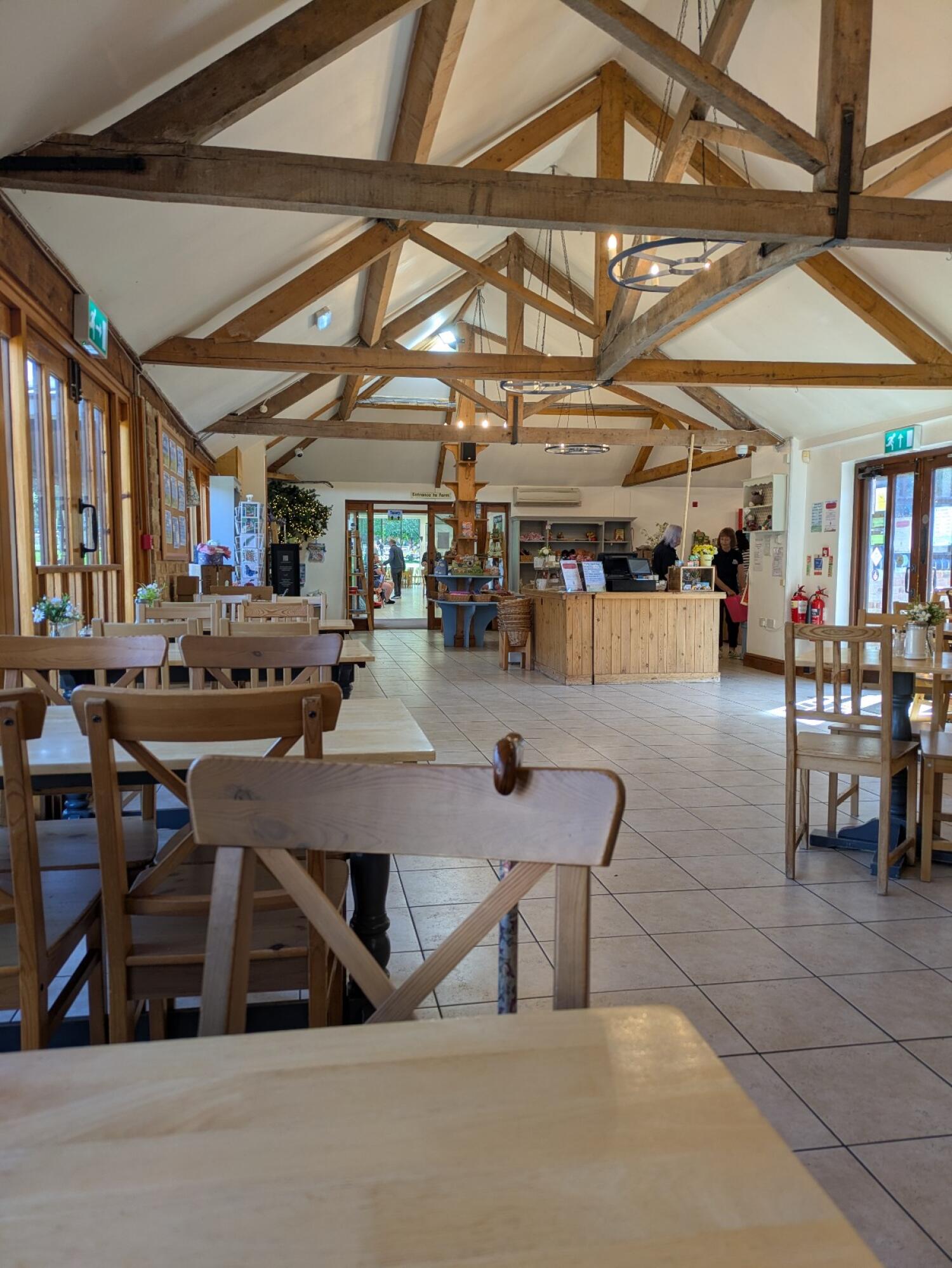 Tables and chairs along left. Tiled path through centre. Service counter and seating right.
