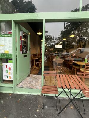 Green wood-framed glass door. Use handle to open.