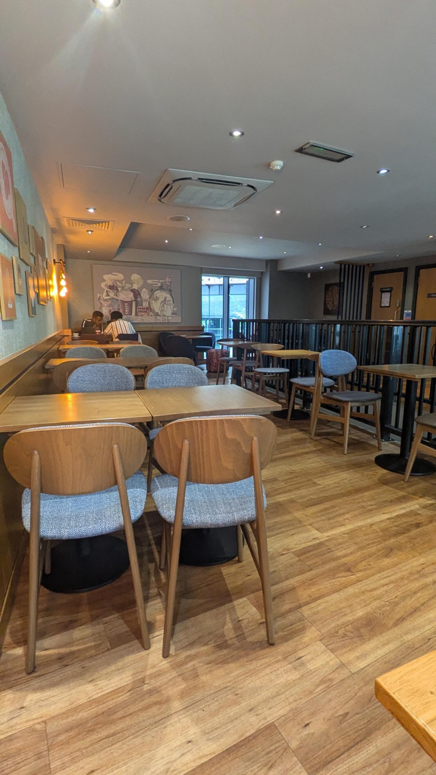 Tables and chairs along left. Tables and chairs in centre. Tables and chairs along right.