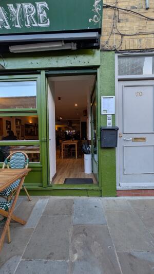 Green wood-framed glass door. Use handle to open.