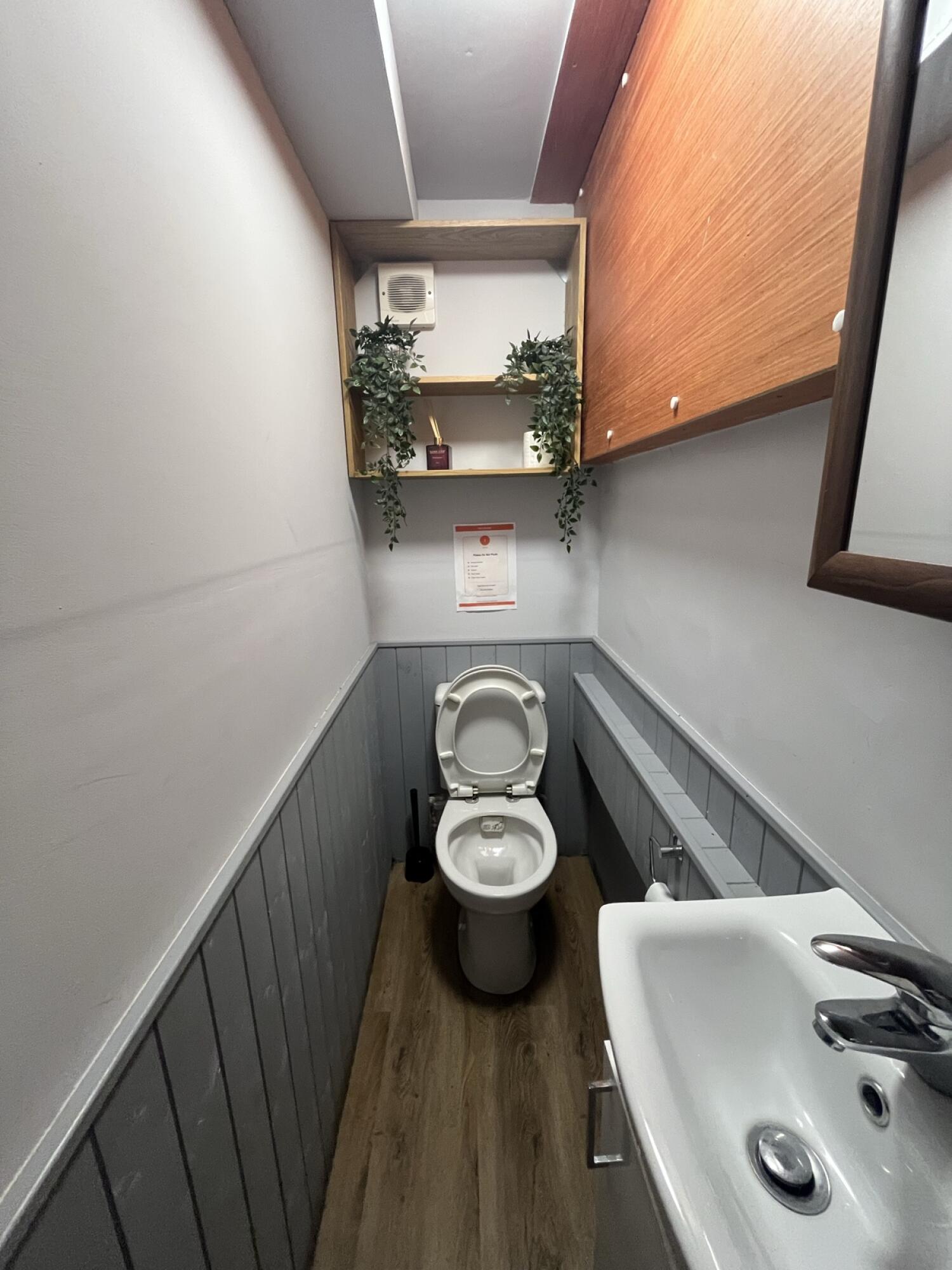 Toilet at back wall. Sink on right.