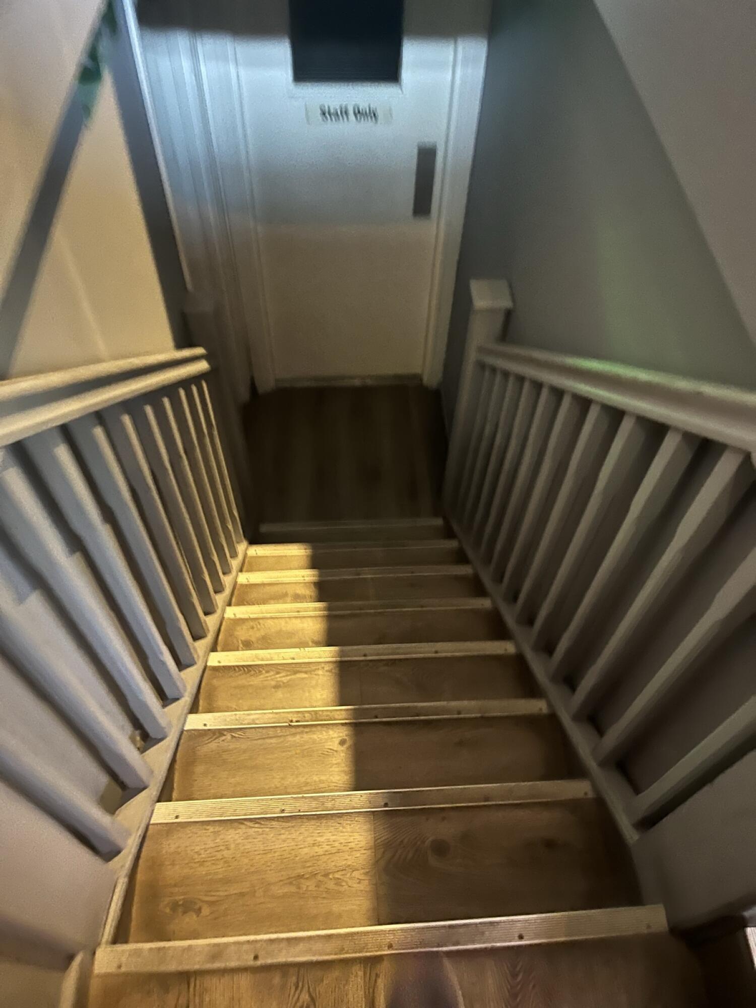 Staircase ahead. Handrails along left and right.