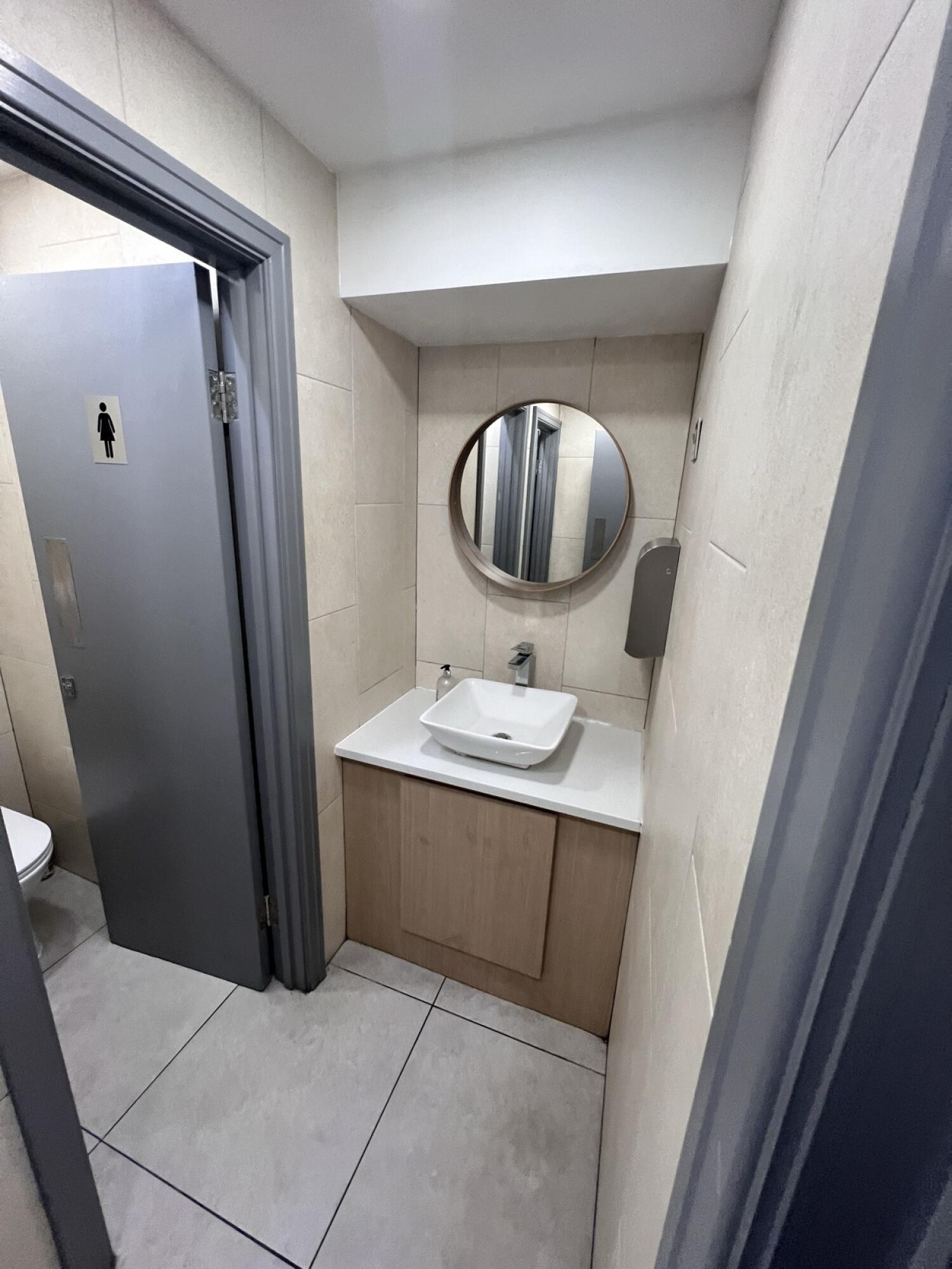 Toilet partially visible on left. Sink at back wall.