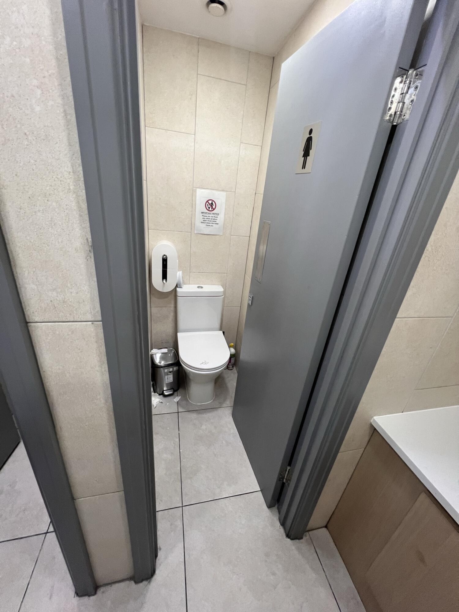 Toilet at back wall.