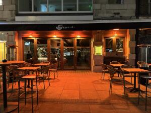 Tables and chairs on left. Entrance doors in centre. Tables and chairs on right.