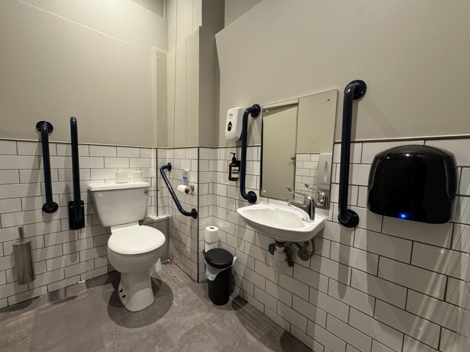 Toilet left of back wall. Sink on right wall.