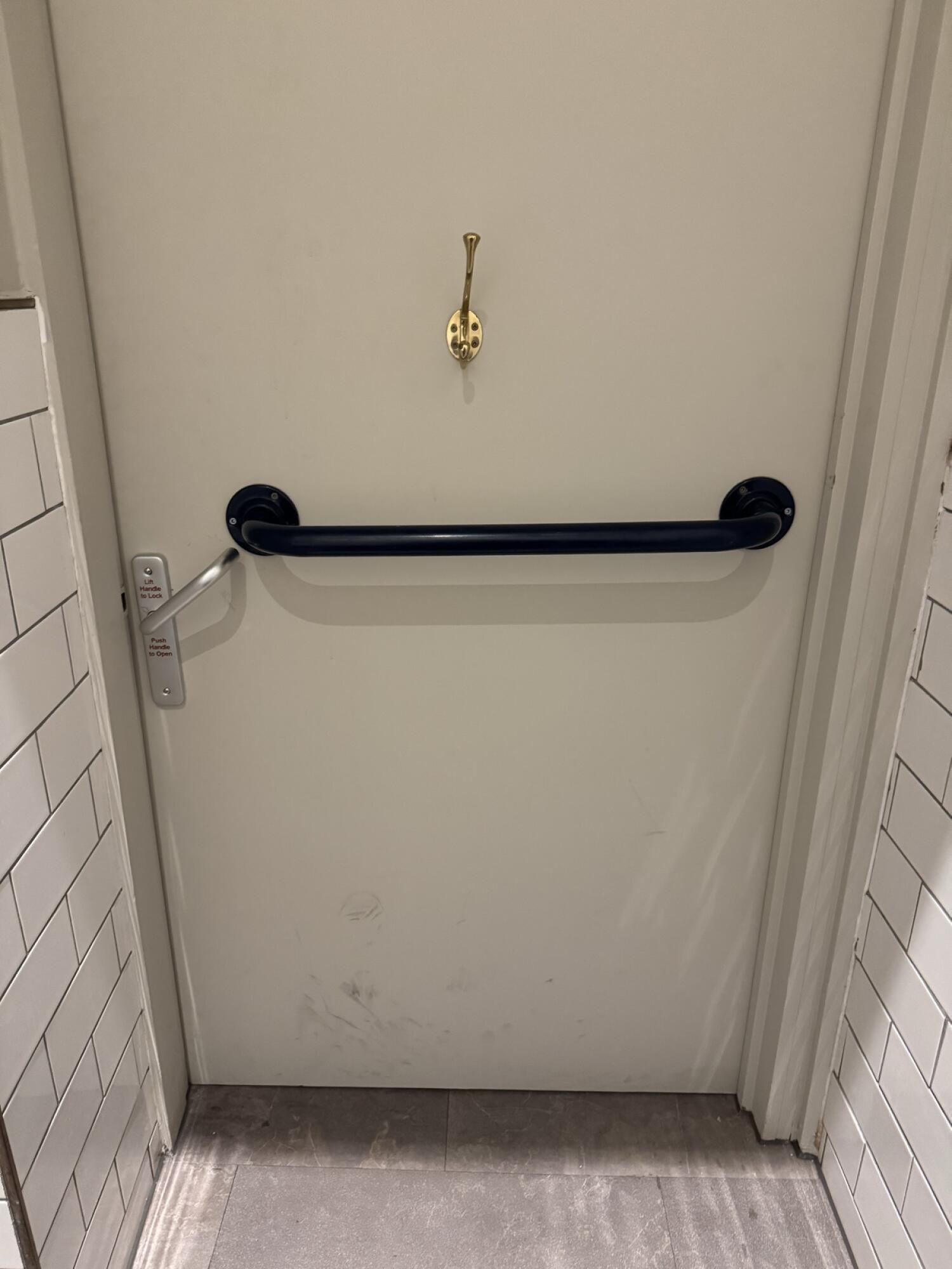 Grab rail in centre. Push handle on left to open.