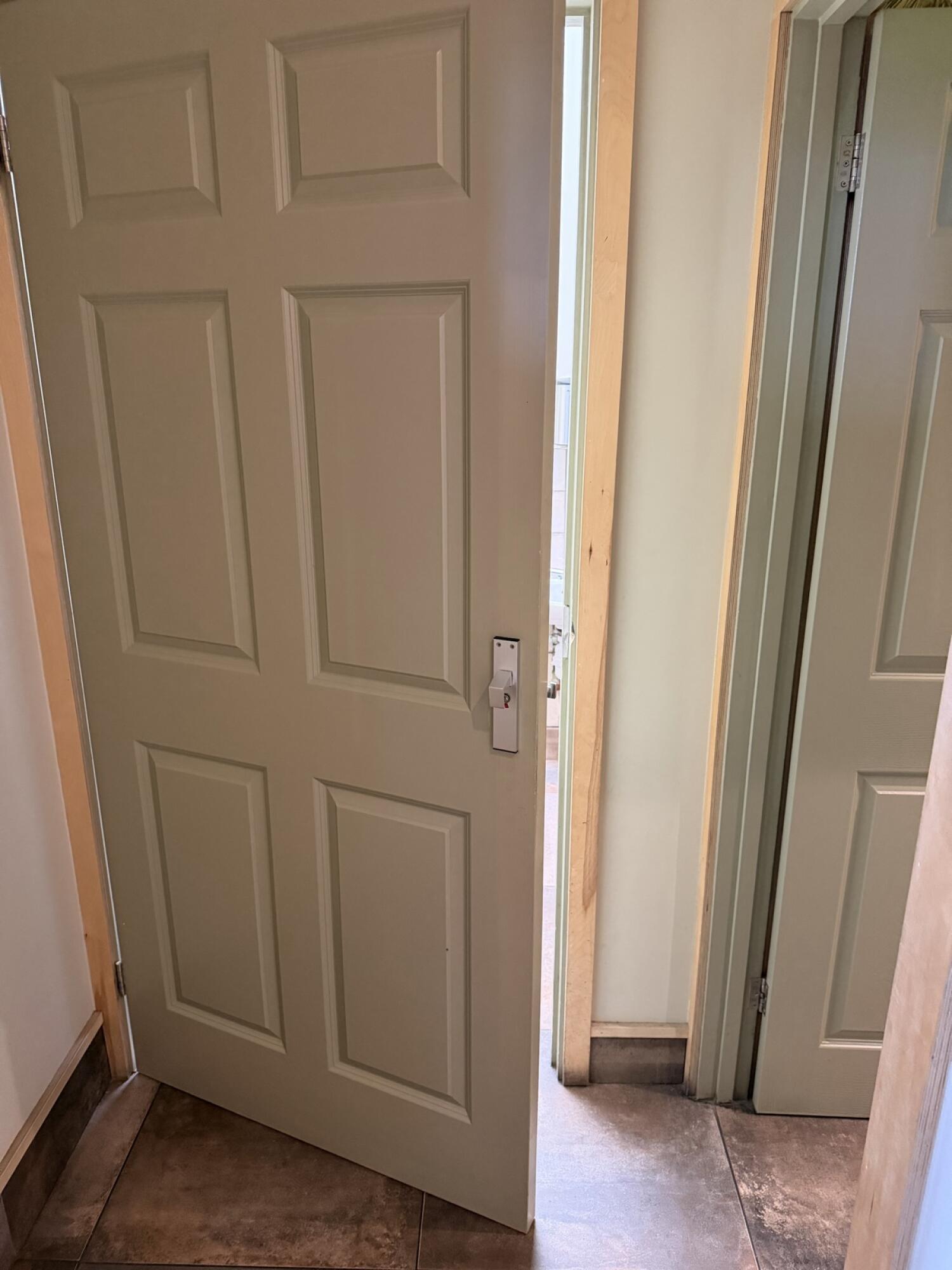 Beige painted wood door. Use handle to open.