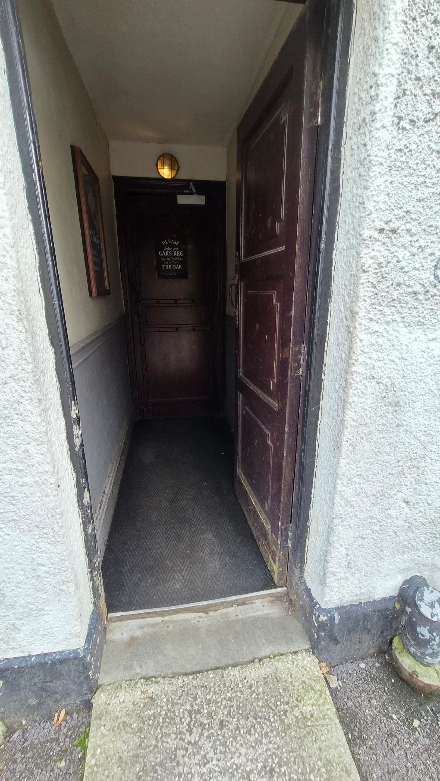 Dark brown wooden door. Use handle to open.