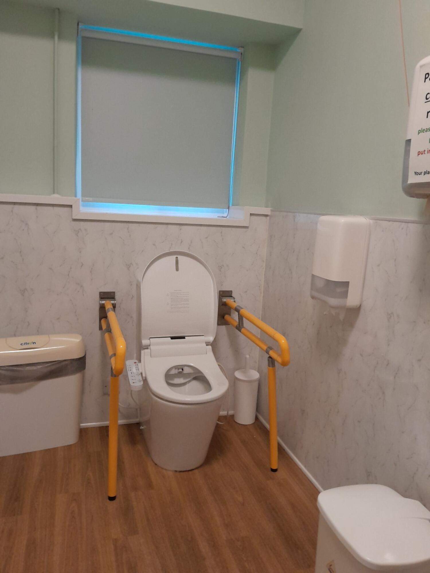Sink on left wall. Toilet at back wall. Emergency pull cord on right wall.