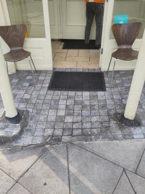 Small bump at foot of door. Doormats before and after door.