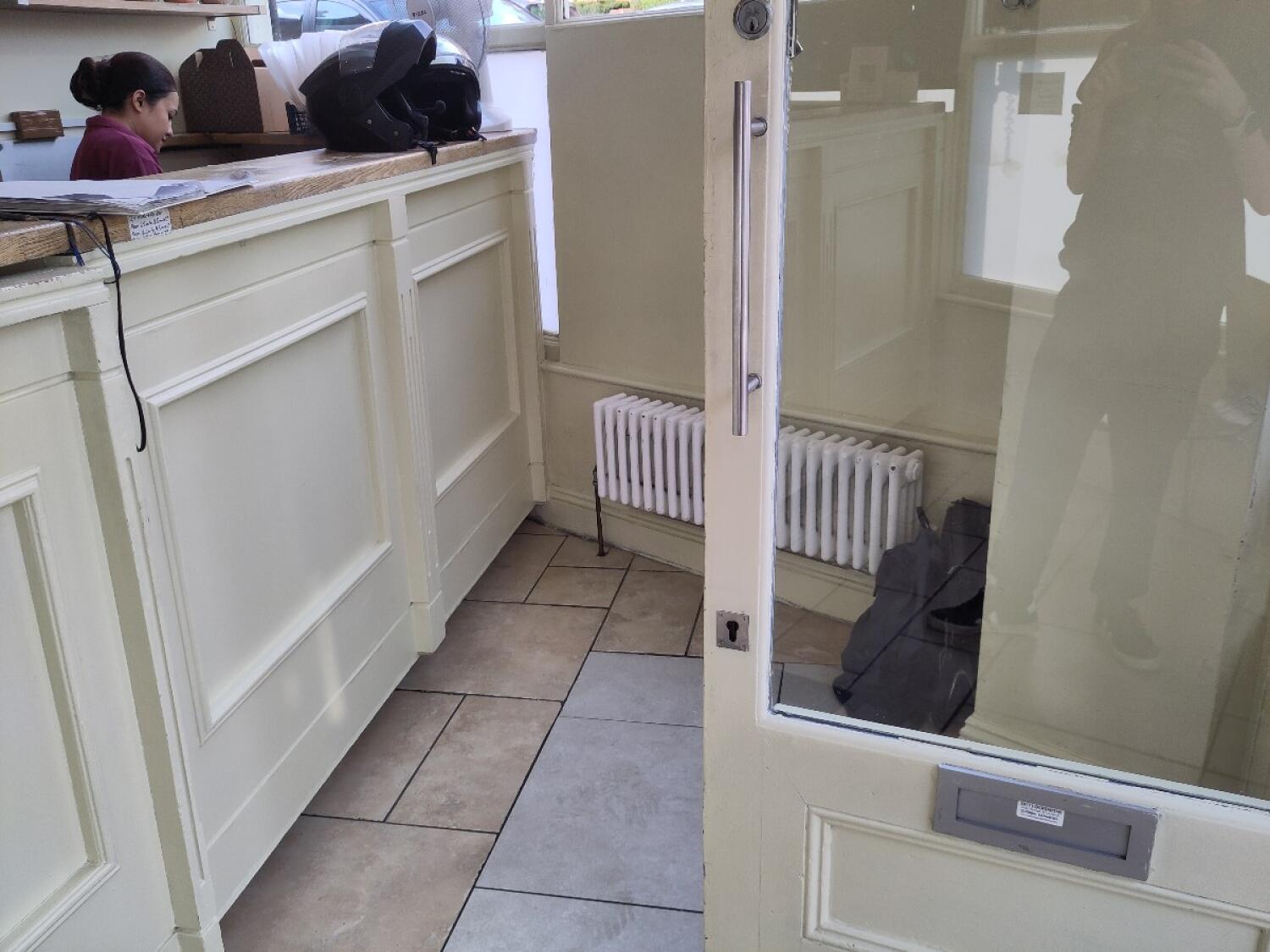 Cream wood-framed glass door. Use handle to open.